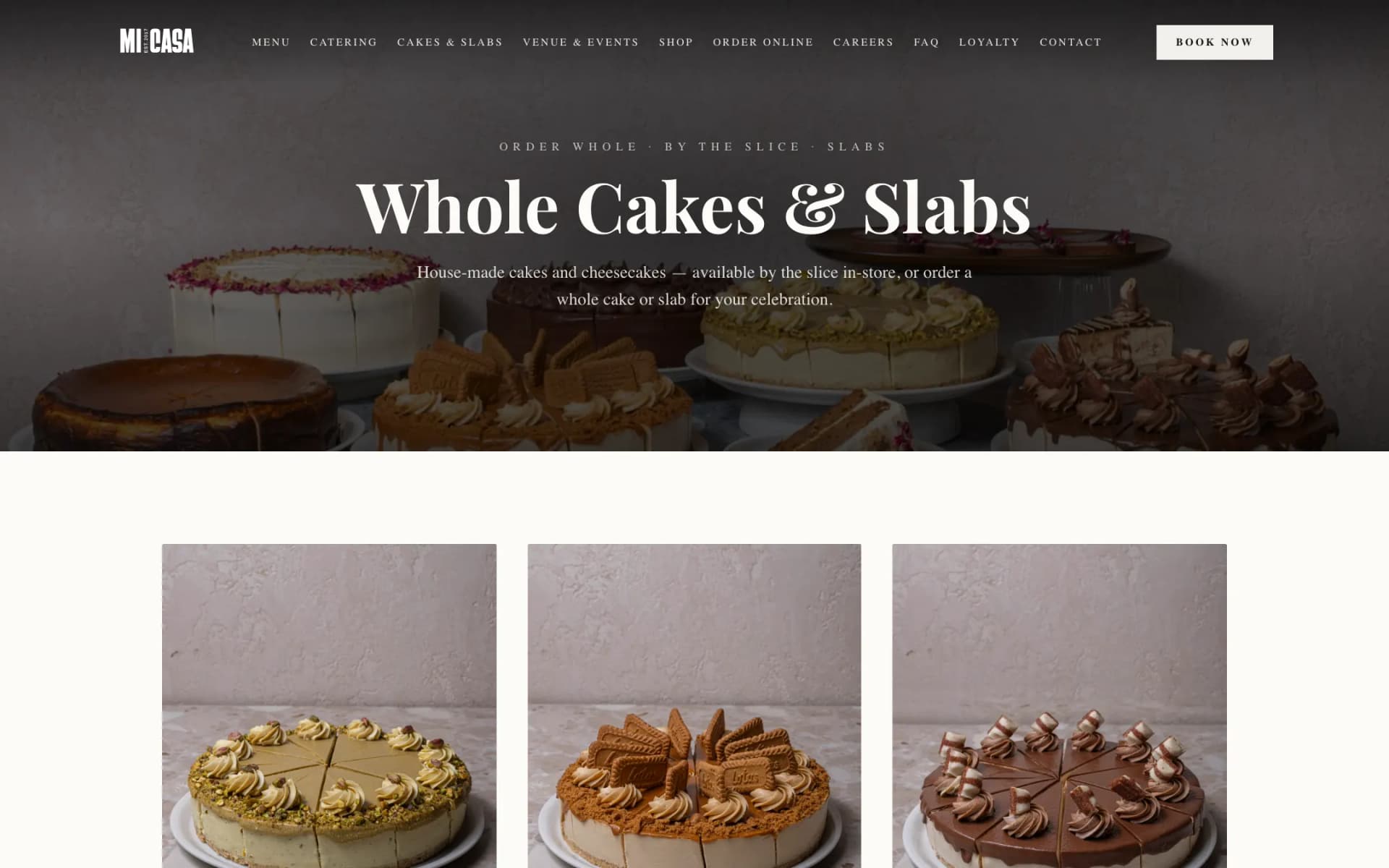 Cakes page hero with the heading 'Whole Cakes & Slabs' over a dimmed photo of assorted cheesecakes, above the first row of product photos: pistachio, Biscoff and Kinder Bueno cakes on terrazzo